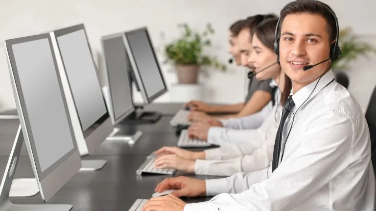 Customer Service Team Working at Computers with Headsets