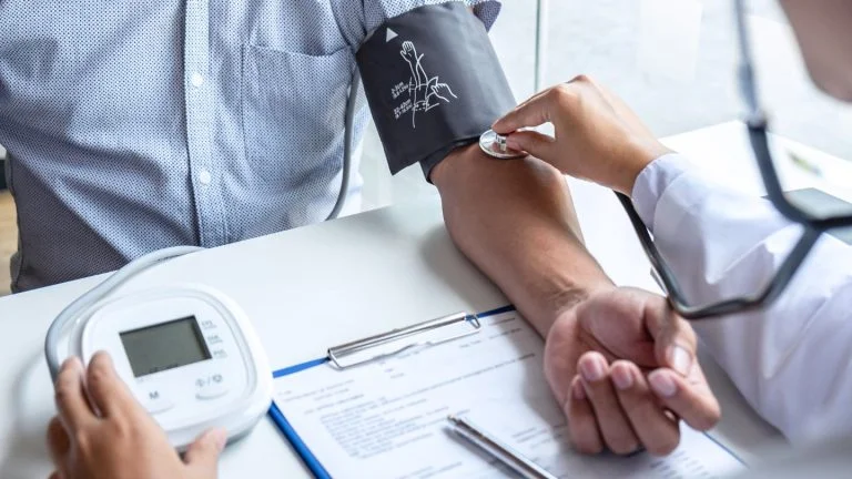 Doctor Taking Patient's Blood Pressure During Check-up